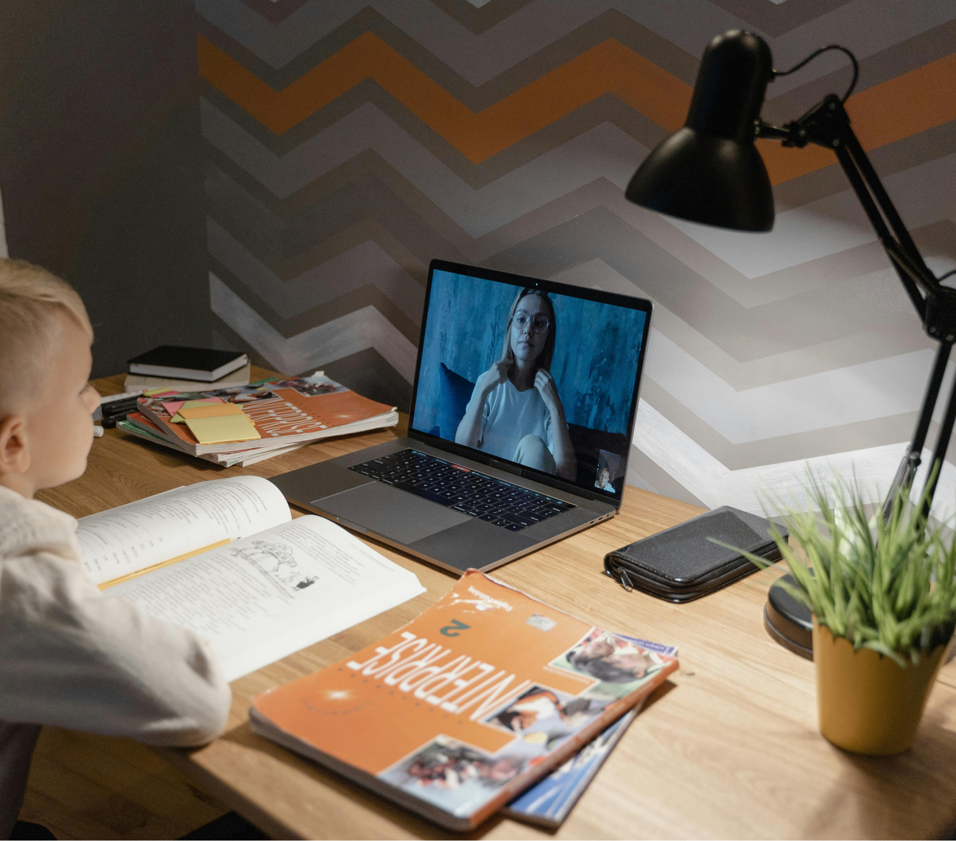 Hero secion image with some kids studying on a desk with a laptop